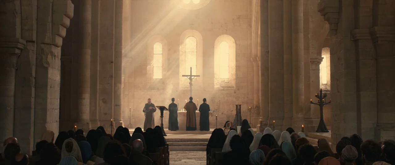 Benedetta (2021) movie still: wide — A stone cathedral interior features high arches and large windows behind an altar. Four robed figures stand at…