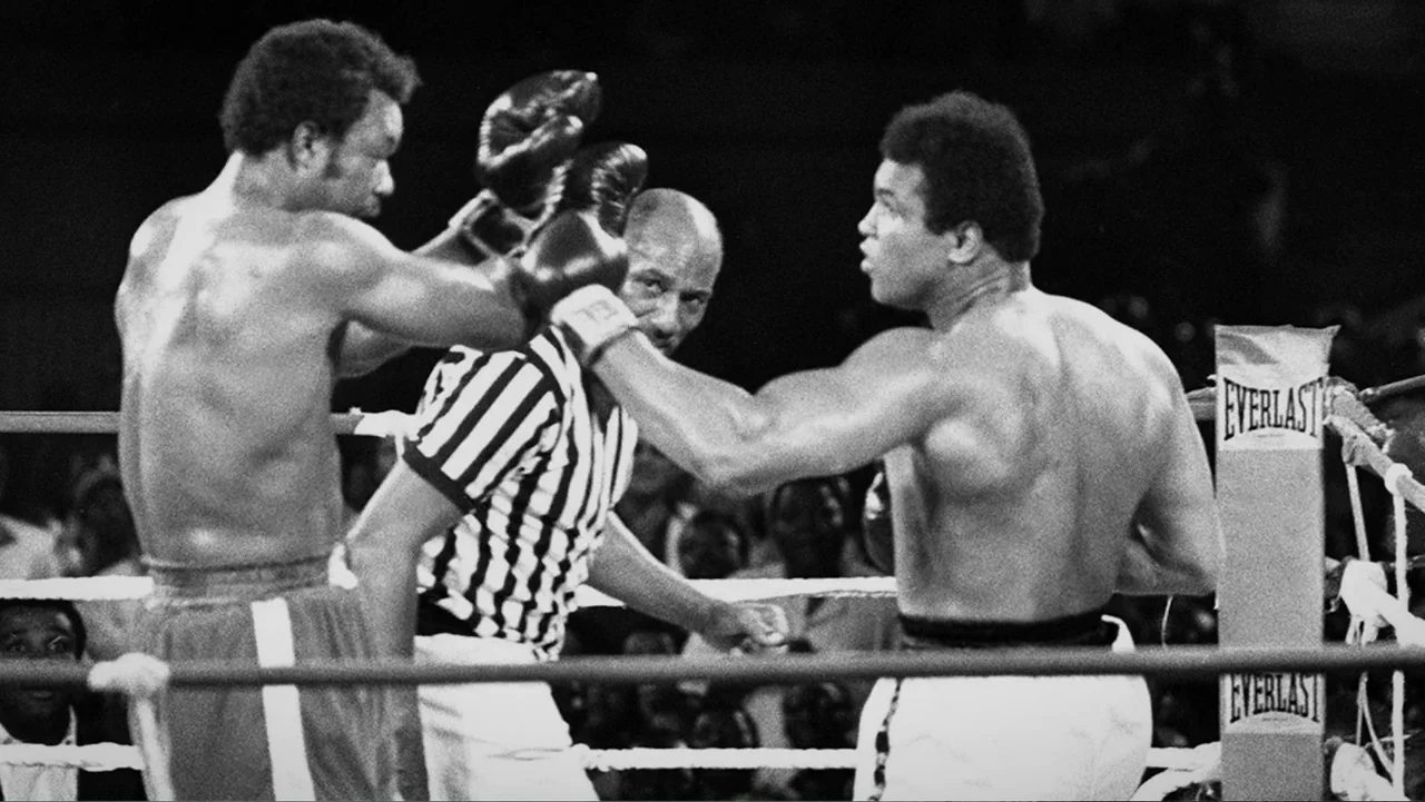 Ali & Cavett: The Tale of the Tapes (2018) movie still: medium — A brightly lit professional boxing ring with white ropes and corner padding. Two…