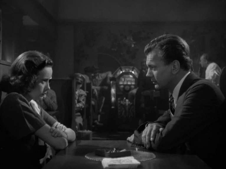 Shadow of a Doubt (1943) movie still: medium — A dimly lit booth inside a vintage eatery features a dark wooden table. A man and a woman sit…
