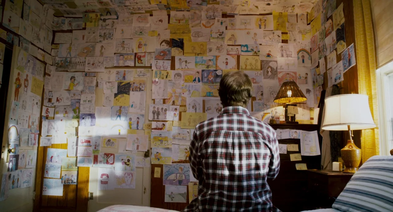 Super (2010) movie still: medium — A bedroom wall is completely covered with hundreds of individual hand-drawn sketches and diagrams. A man wearing…