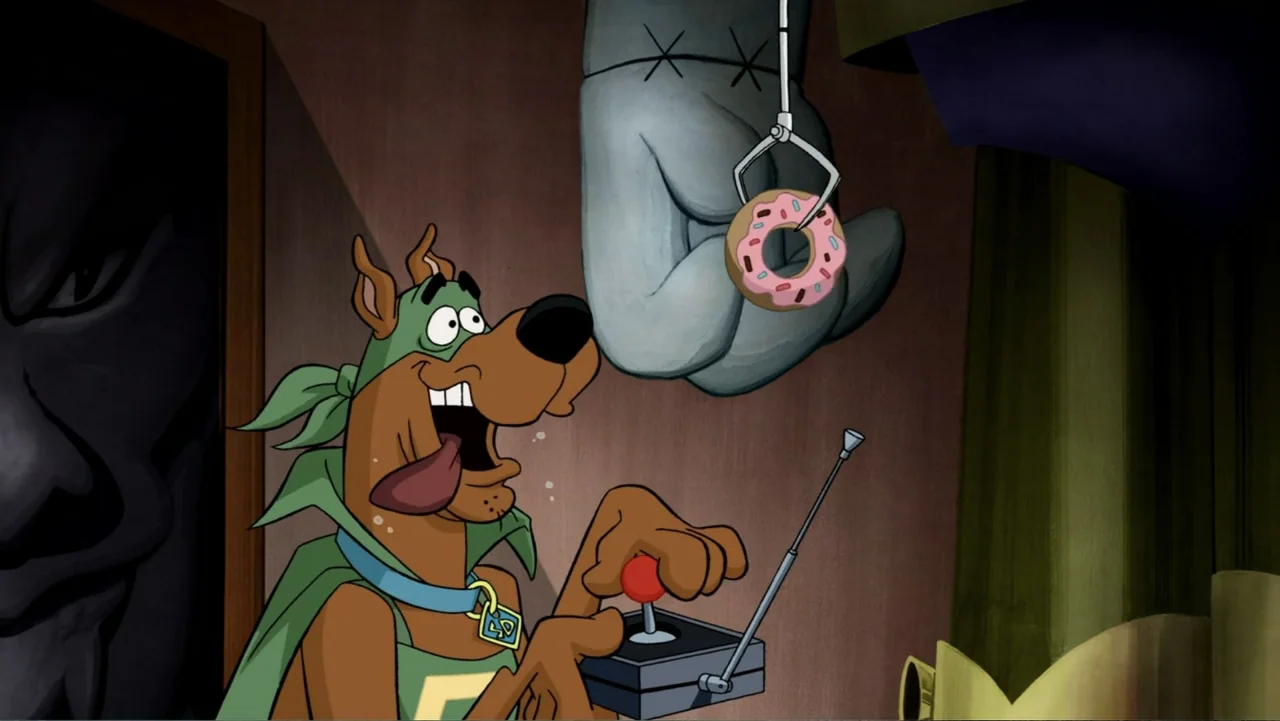 Scooby-Doo! Mask of the Blue Falcon (2012) movie still: medium — A cartoon dog wearing a green mask and cape stands in an indoor space. The dog uses…