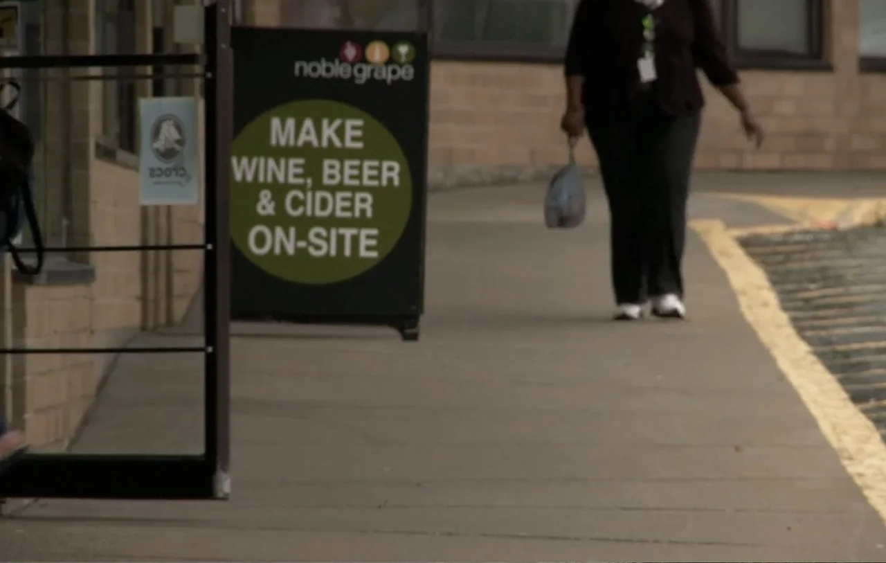 No Place to Hide (1992) movie still: medium — A sidewalk runs alongside a brick building with a business advertisement sign. A person walks along…