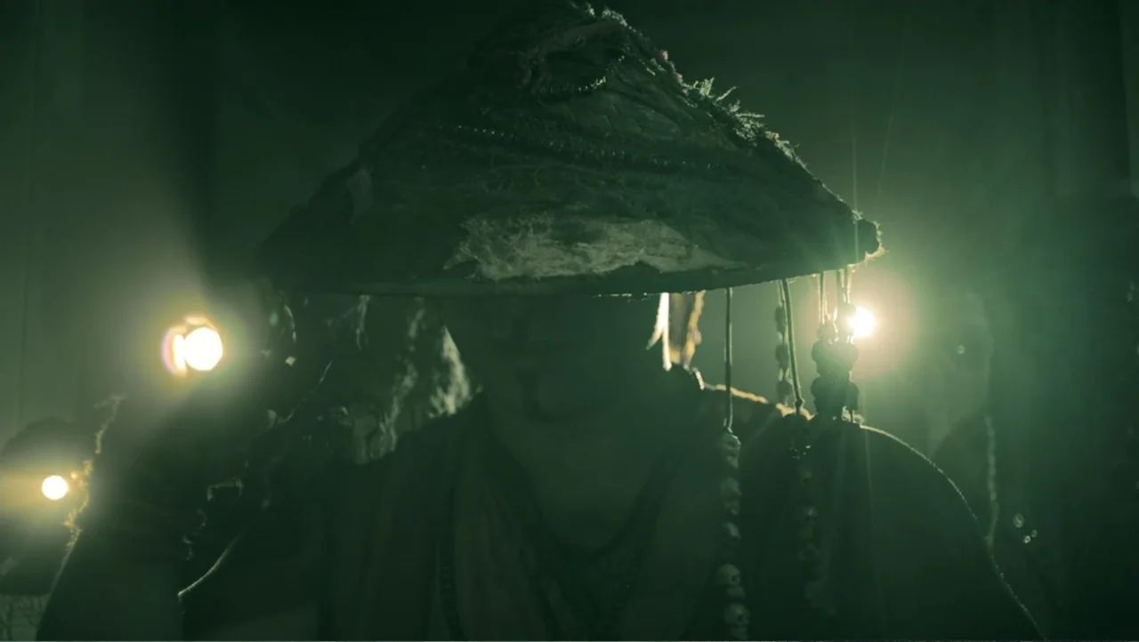 Shadow Master (2022) movie still: closeup — A dark space filled with atmospheric haze is illuminated by two small practical lights. A person wearing…