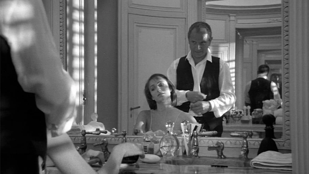 Under The Cherry Moon (1986) movie still: medium — An upscale, marble-countered bathroom features a large mirror reflecting two people standing…
