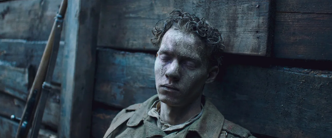 All Quiet on the Western Front (2022) movie still: medium — A soldier leans against the weathered timber walls of a war-time defensive trench. He is…