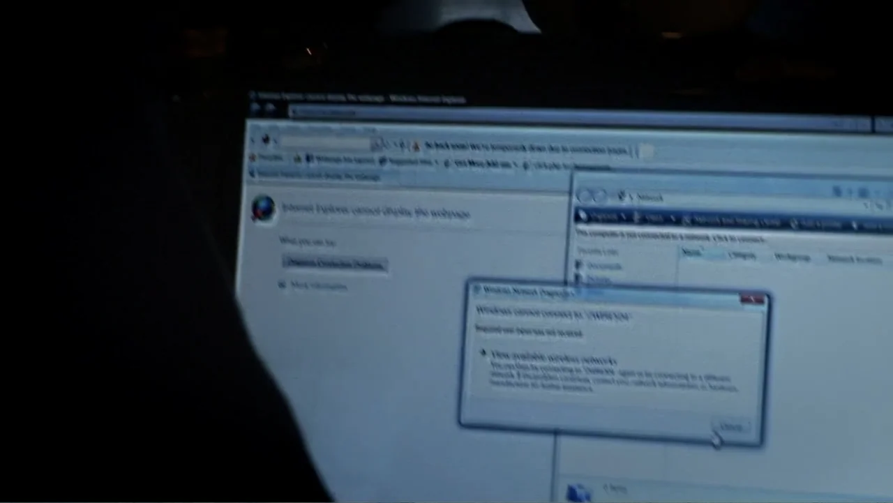The Cheshire Murders (2013) movie still: closeup — A close-up view of a laptop screen displays a Windows connection error message. The interface…