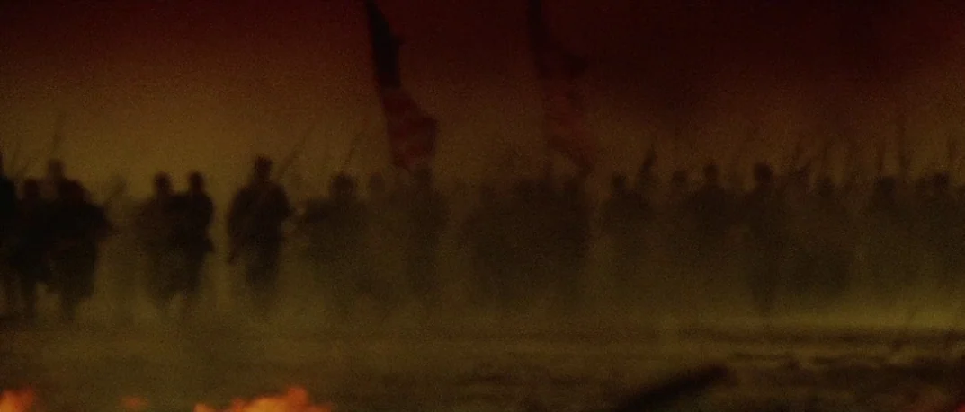 Cold Mountain (2003) movie still: wide — A dark, smoke-filled field during a nineteenth-century battle at night. Numerous silhouetted soldiers carry…
