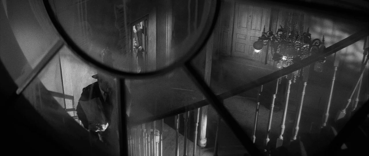 The Tarnished Angels (1957) movie still: wide — A dark, multi-storied Victorian-style staircase viewed through a glass panel from above. The…