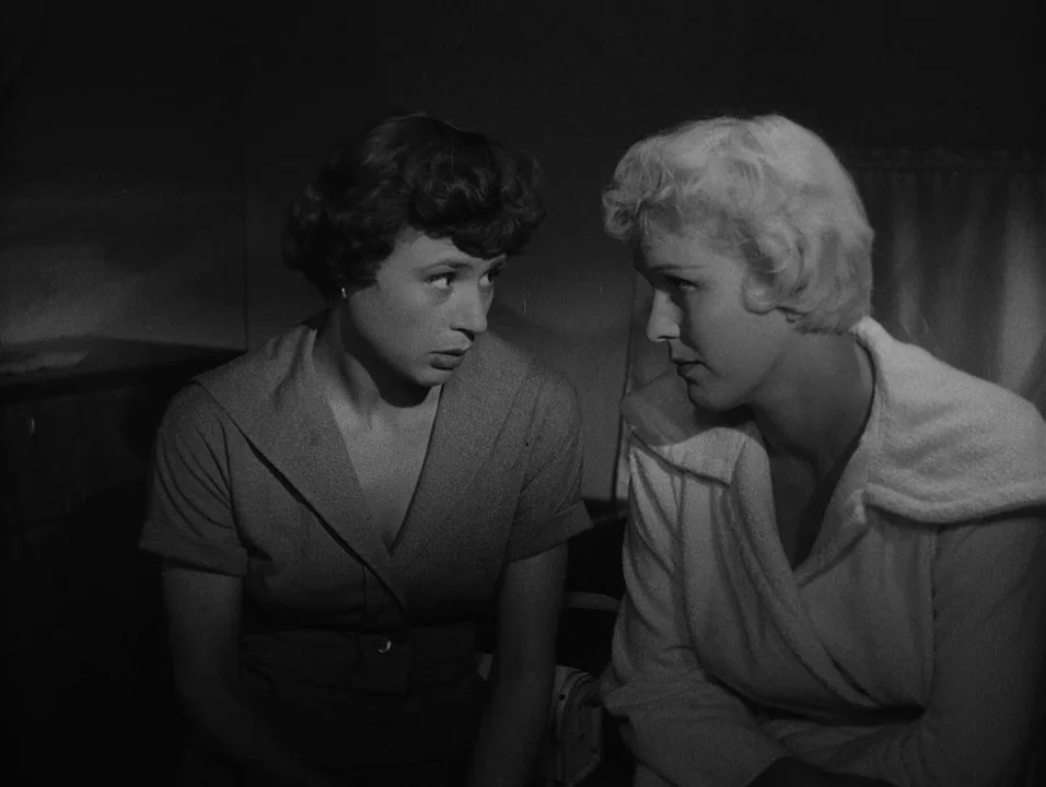 Dreams (1955) movie still: medium — Two women sit side by side in a dim, enclosed interior space. They gaze at one another while one speaks to the…