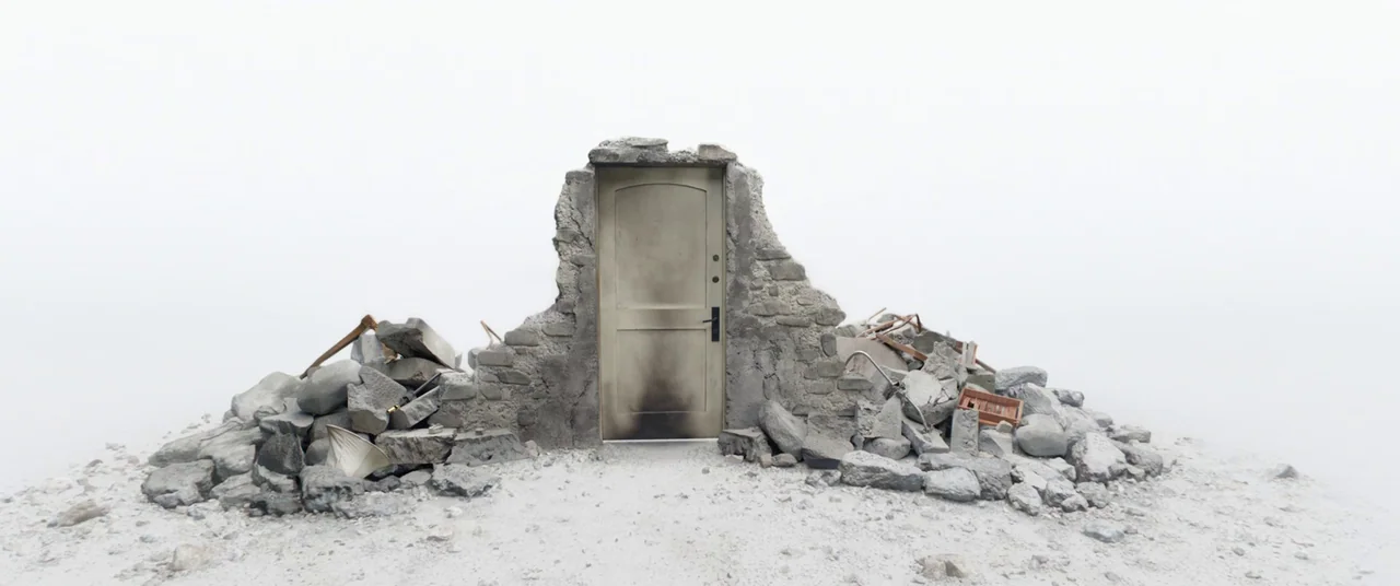 Doctor Strange in the Multiverse of Madness (2022) movie still: wide — A single door stands framed by a partial stone wall amidst a white void.…