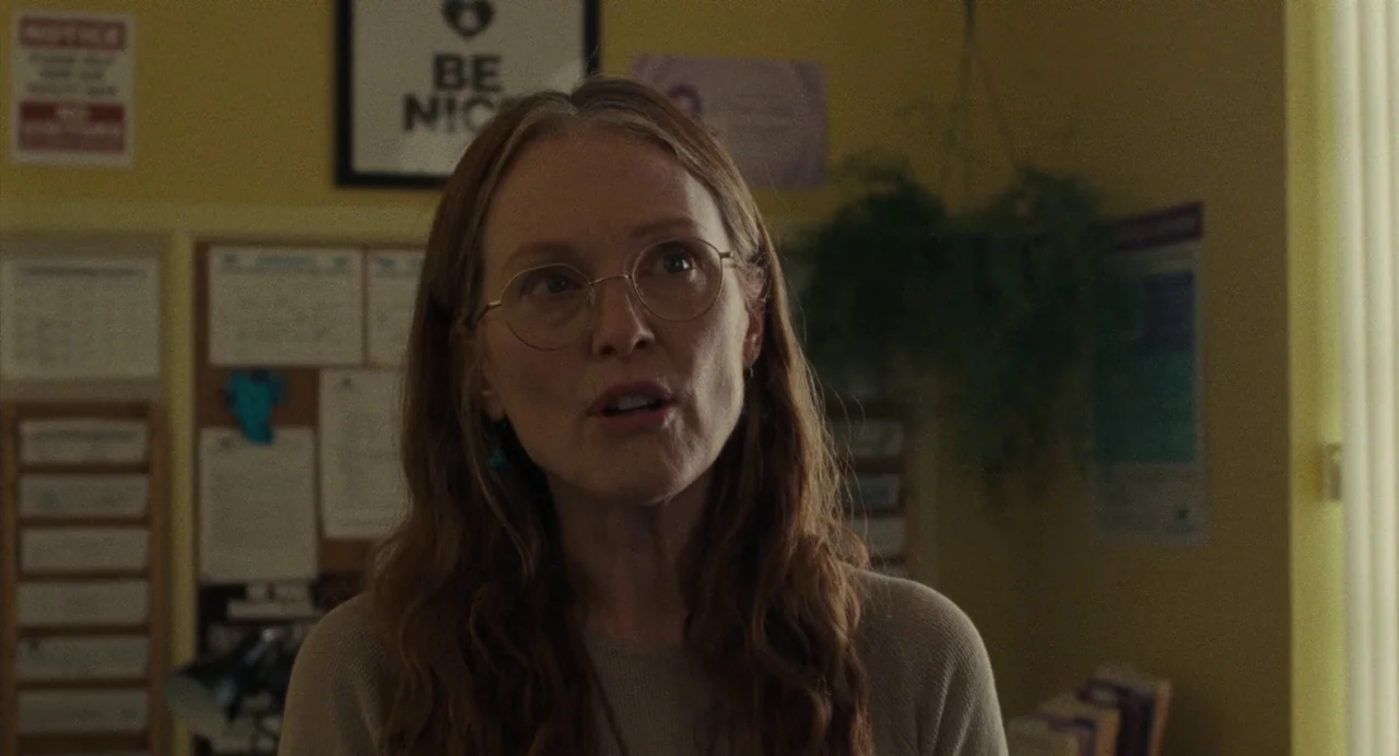 When You Finish Saving The World (2022) movie still: closeup — A community center office features yellow walls adorned with cork boards and posters.…