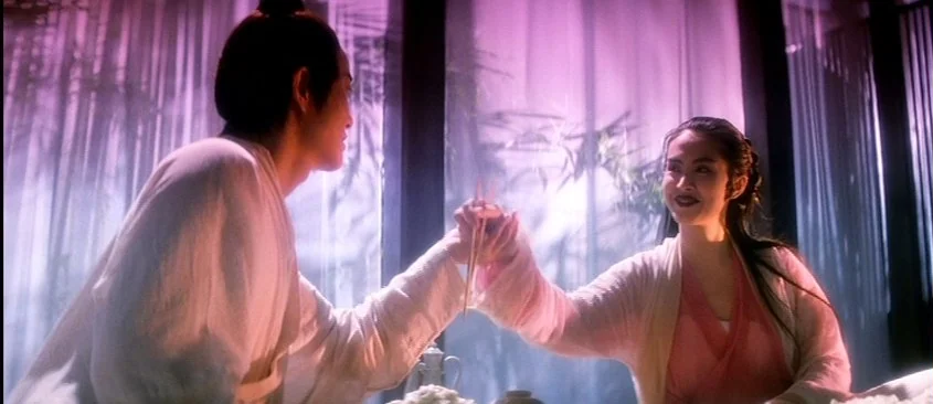 Green Snake (1993) movie still: medium — An interior space with translucent bamboo screens and soft, purple-tinted light filtering through. A man…