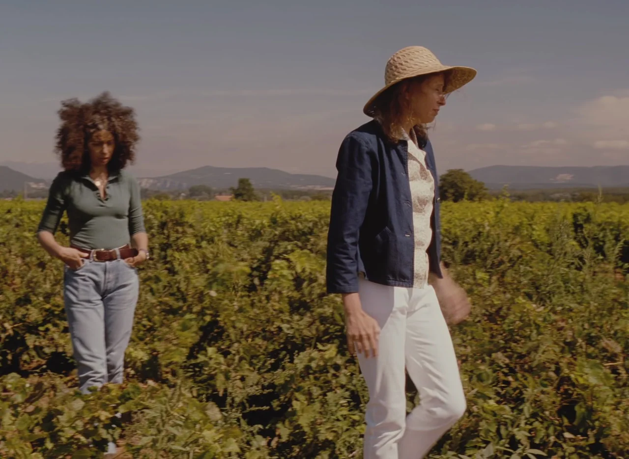 Autumn Tale (1998) movie still: fullbody — An expansive sun-drenched vineyard stretches toward distant hills under a clear sky. Two women walk…