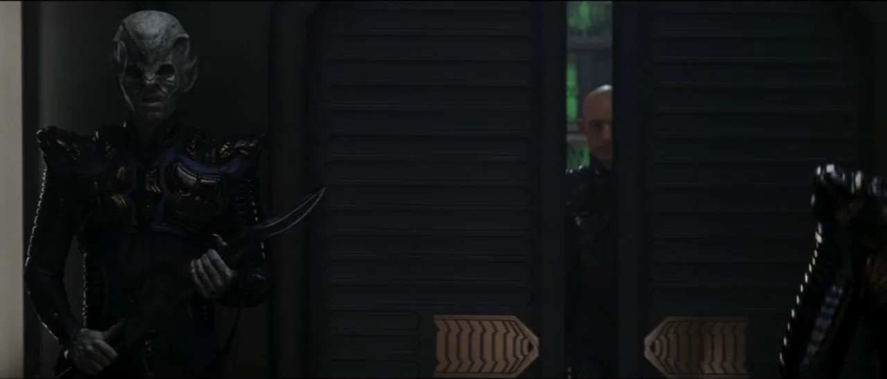 Star Trek: Nemesis (2002) movie still: medium — A dark futuristic corridor features metallic paneled walls and a partially open sliding door. An…