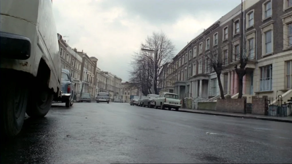 The Sorcerers (1967) movie still: establishing — An urban London residential street features rows of mid-Victorian terraced brick houses. Several…
