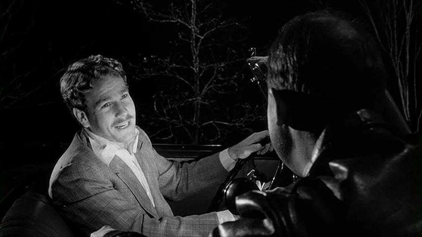Paper Moon (1971) movie still: medium — The interior of a car at night with a dark landscape visible outside. A man in a plaid suit speaks to a…