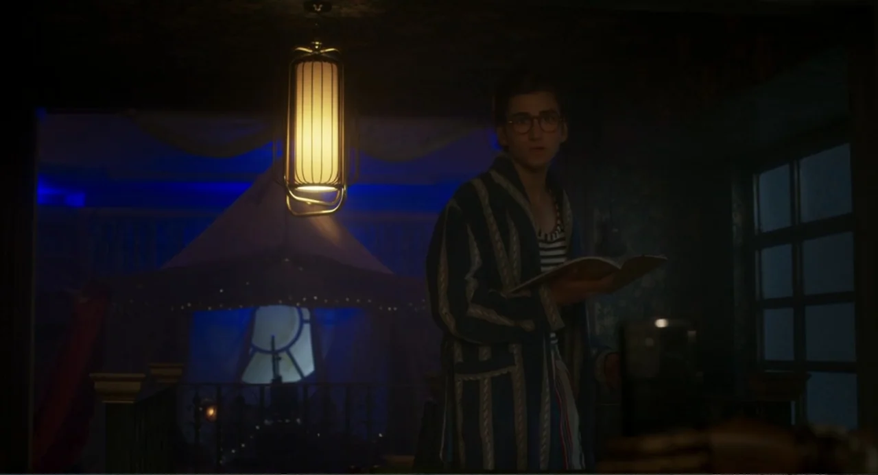 How to Date Billy Walsh (2024) movie still: medium — A dimly lit indoor space features a fabric-draped tent structure in the background. A young man…