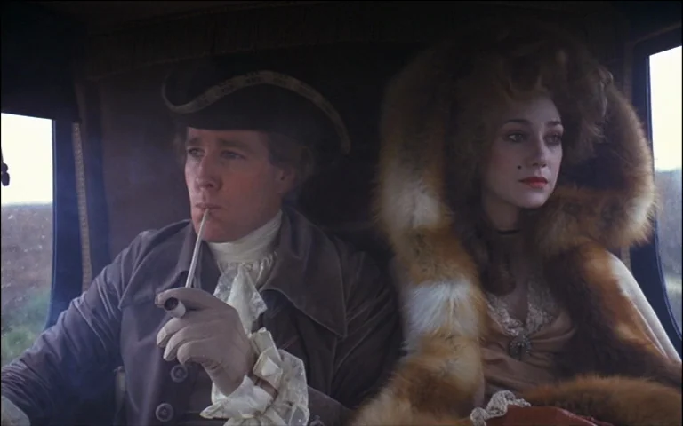 Barry Lyndon (1975) movie still: medium — A man and woman sit inside an old carriage with wood-paneled walls. The man holds a white pipe to his…