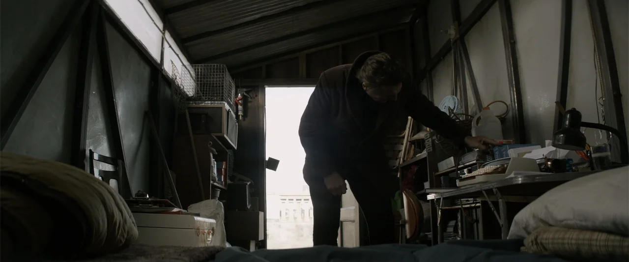A Walk Among the Tombstones (2014) movie still: medium — A cluttered interior of a small wooden shed with tools and miscellaneous items stored…