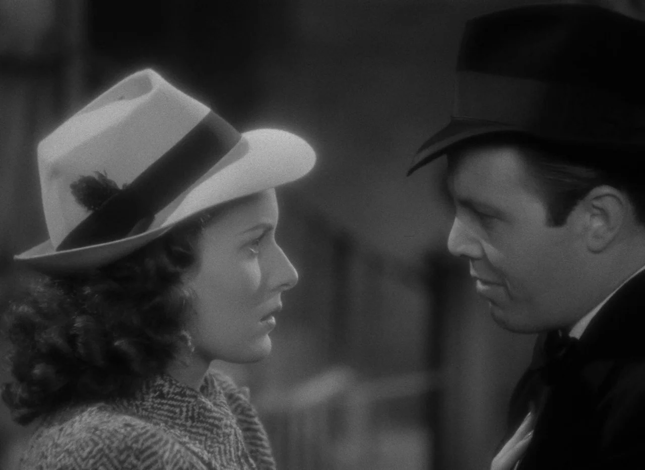 Dance, Girl, Dance (1940) movie still: medium — A man and a woman stand close together in a dimly lit outdoor location. They are positioned in…