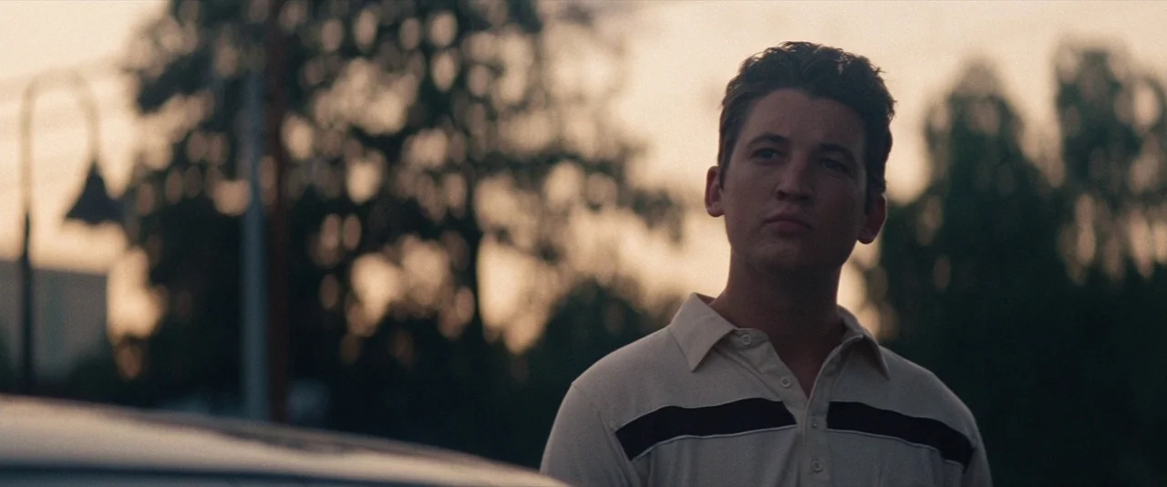 The Spectacular Now (2013) movie still: medium — An outdoor location during sunset with blurred trees in the background behind the subject. A young…