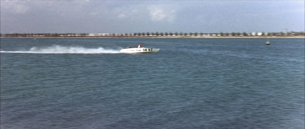 Clambake (1967) movie still: wide — A wide view of a large body of water under a bright sky. A white speedboat with registration markings moves…