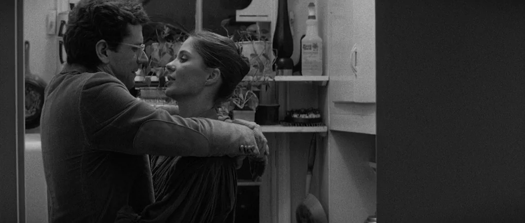 Manhattan (1979) movie still: medium — A residential setting with cabinets, a potted plant, and various household objects visible. A man and a woman…