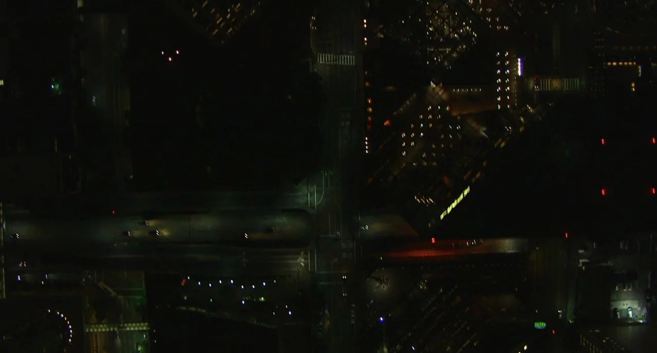 We Are Your Friends (2015) movie still: establishing — An aerial top-down view shows dark urban roads and intersections at night. Small pinpoints of…