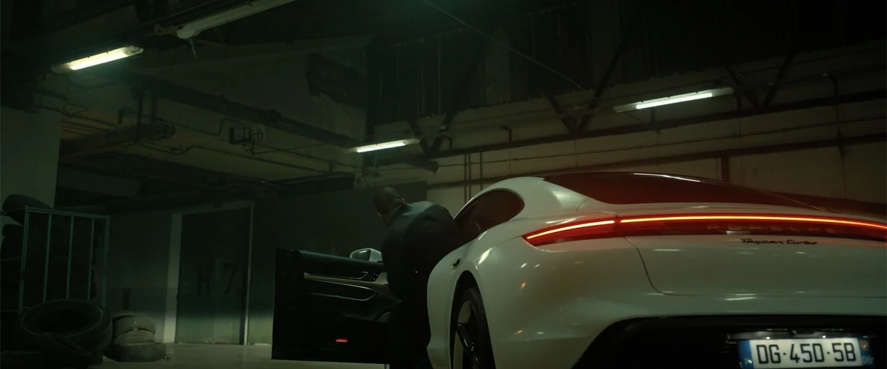 Den of Thieves 2: Pantera (2025) movie still: medium — A dark, industrial concrete parking garage features exposed ceiling pipes and fluorescent…
