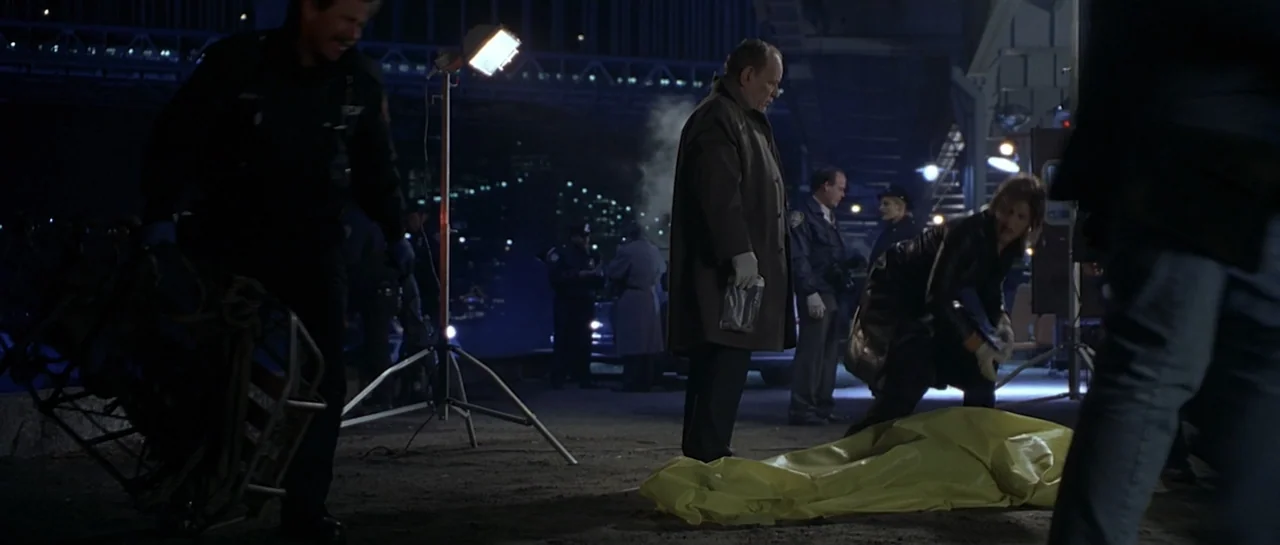 Don't Say a Word (2001) movie still: fullbody — An outdoor night crime scene beneath a bridge features investigators near a body. A person in a…