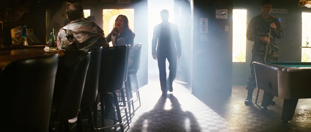 The Incredible Hulk (2008) movie still: fullbody — A dimly lit room features a pool table and bar stools arranged in rows. A man in a suit enters…
