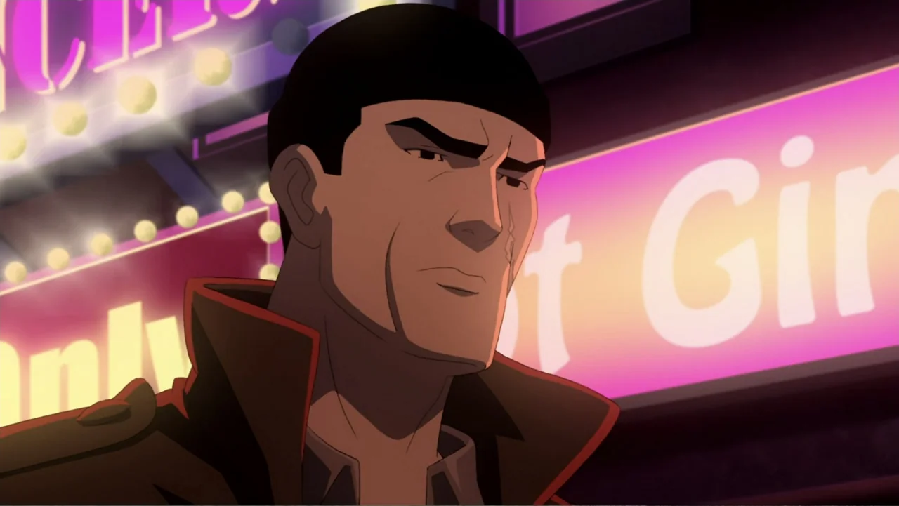 Batman: Year One (2011) movie still: closeup — A man stands before a bright pink neon sign on a dark city street. He wears a heavy trench coat and…