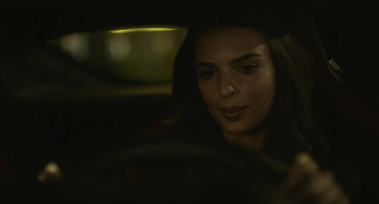 We Are Your Friends (2015) movie still: closeup — A dark vehicle interior at night with limited light on the driver. A young woman with long dark…