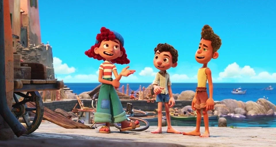 Luca (2021) movie still: fullbody — A sunny coastal pier features three children standing and talking near the water. Boats and rocky formations are…