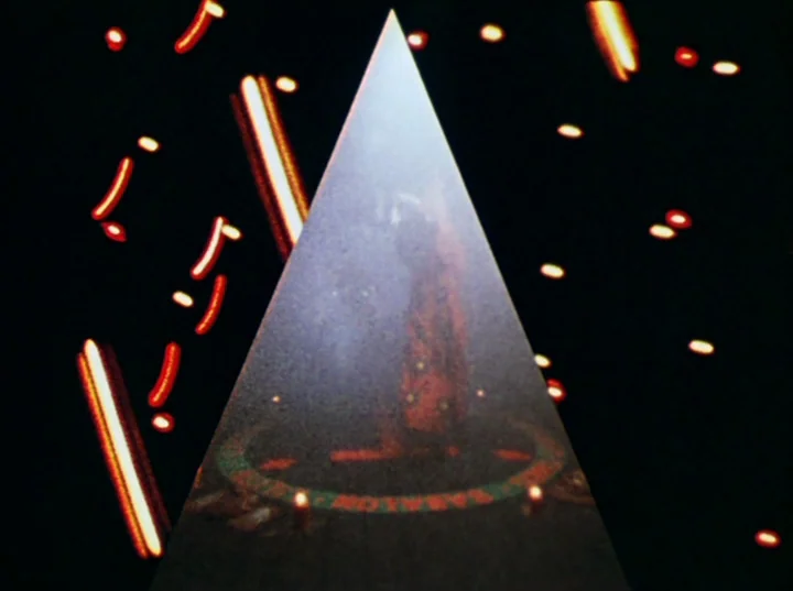 Lucifer Rising (1972) movie still: wide — A dark, void-like space features a single, prominent, vertically oriented illuminated triangle. Bright,…