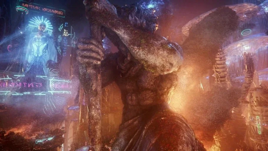 Aquaman and the Lost Kingdom (2023) movie still: wide — A massive, weathered stone statue of a humanoid figure towers over a neon-lit environment.…