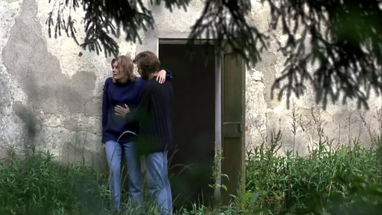 A Quiet Place In The Country (1968) movie still: fullbody — A pair of people stand against a weathered, plastered stone wall next to a doorway. The…