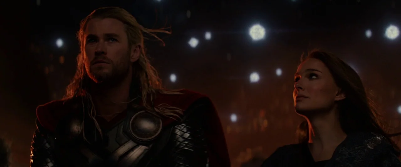 Thor: The Dark World (2013) movie still: medium — Two figures stand in an expansive dark void filled with small, bright floating particles. They…