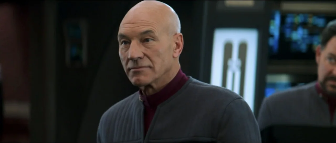 Star Trek: Nemesis (2002) movie still: medium — A high-tech starship bridge interior features dark grey metallic panels and illuminated vertical…