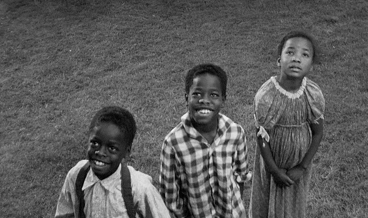 The Miracle Worker (1962) movie still: medium — Three young children stand on a patch of grass looking toward the camera. They are dressed in simple…