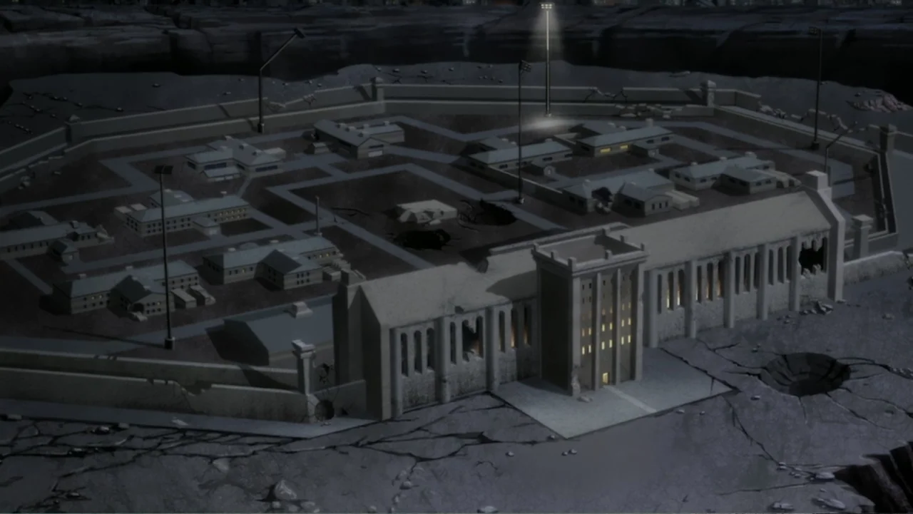 Justice League Dark: Apokolips War (2020) movie still: establishing — A high-angle view of a desolate, walled prison facility at night. Multiple…