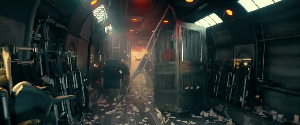 Bad Boys: Ride or Die (2024) movie still: wide — The interior of an aircraft cargo hold features rows of seats and scattered debris. A man in an…