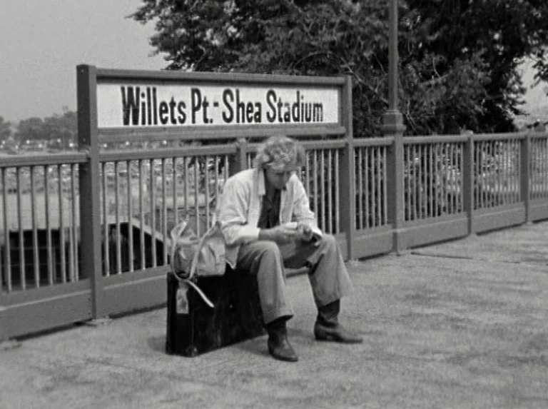 Alice in the Cities (1974) movie still: fullbody — A metal subway platform railing features a sign reading Willets Pt - Shea Stadium. A lone man in…