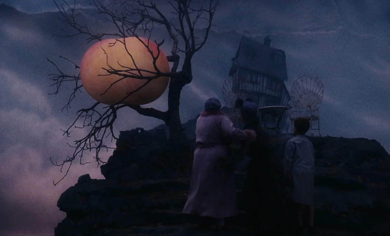 James and the Giant Peach (1996) movie still: wide — A dark, moody hilltop at night featuring a silhouetted house and bare tree. Three people stand…