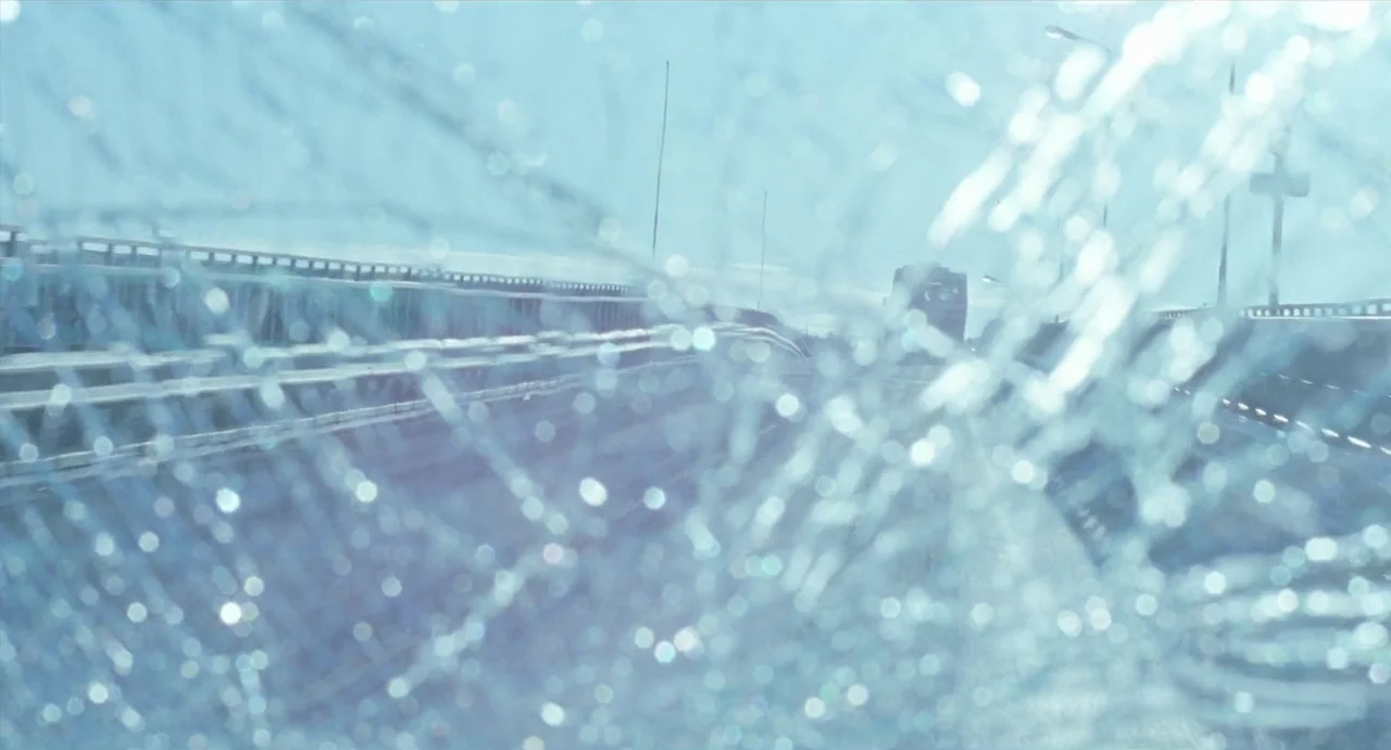 Insomnia (1997) movie still: establishing — An open highway bridge stretches across the frame beneath an overcast, bright daylight sky. A shattered…