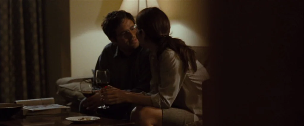 Where The Wild Things Are (2009) movie still: medium — A residential living room contains a sofa and a wooden coffee table at night. A man and woman…