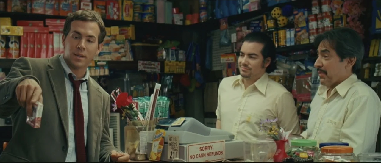 Definitely, Maybe (2008) movie still: medium — A cluttered convenience store checkout counter is filled with merchandise and product displays. Three…