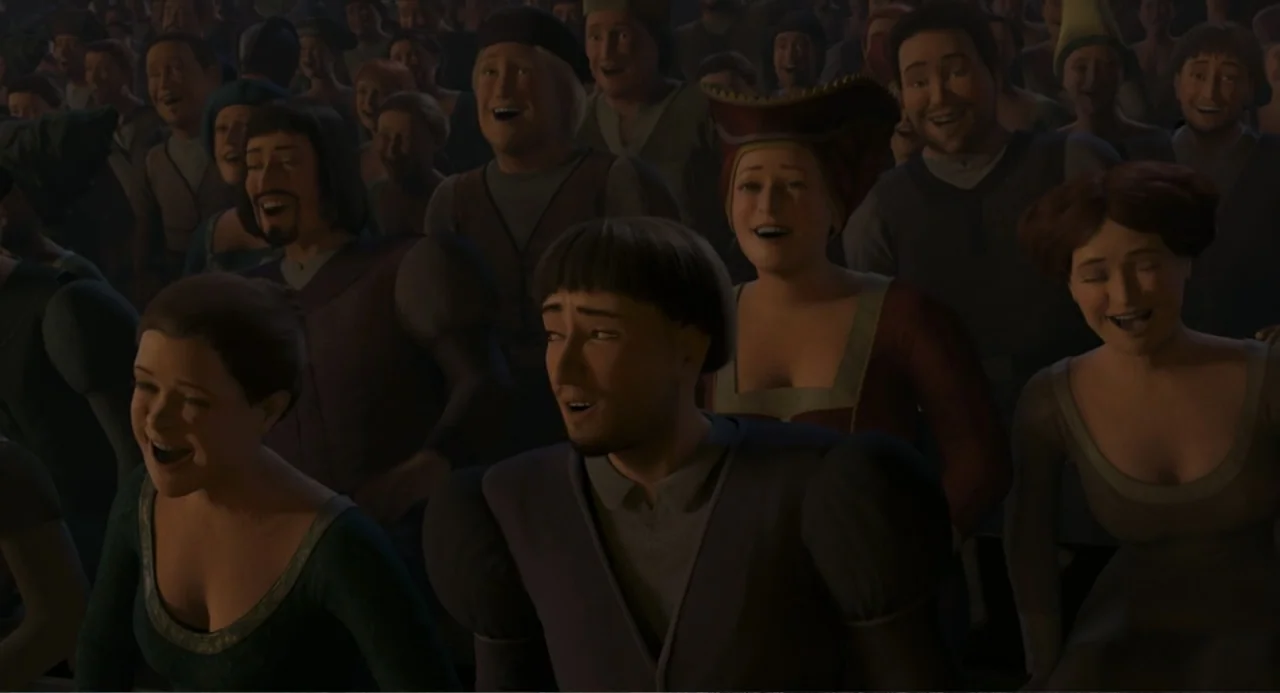 Shrek the Third (2007) movie still: medium — A dense crowd of spectators sits in a dimly lit outdoor fantasy venue. People of various ages react…