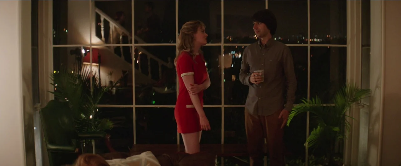 Dean (2016) movie still: medium — A spacious room features a floor-to-ceiling grid window looking out at night city lights. A young man and woman in…