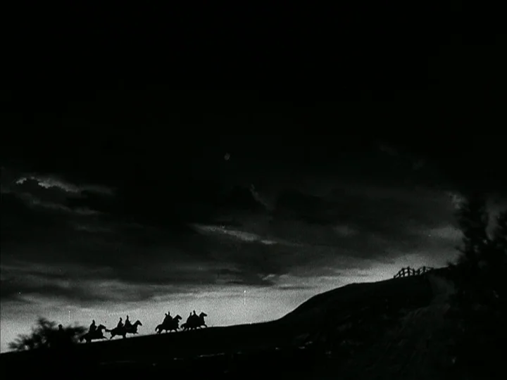 The Black Book (Reign of Terror) (1949) movie still: wide — A group of riders on horseback traverse a ridge against a night sky. Dark clouds loom…